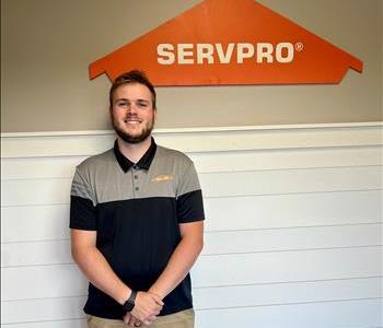 Male employee in front of green SERVPRO vehicle.