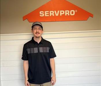 Male employee in front of green SERVPRO vehicle.